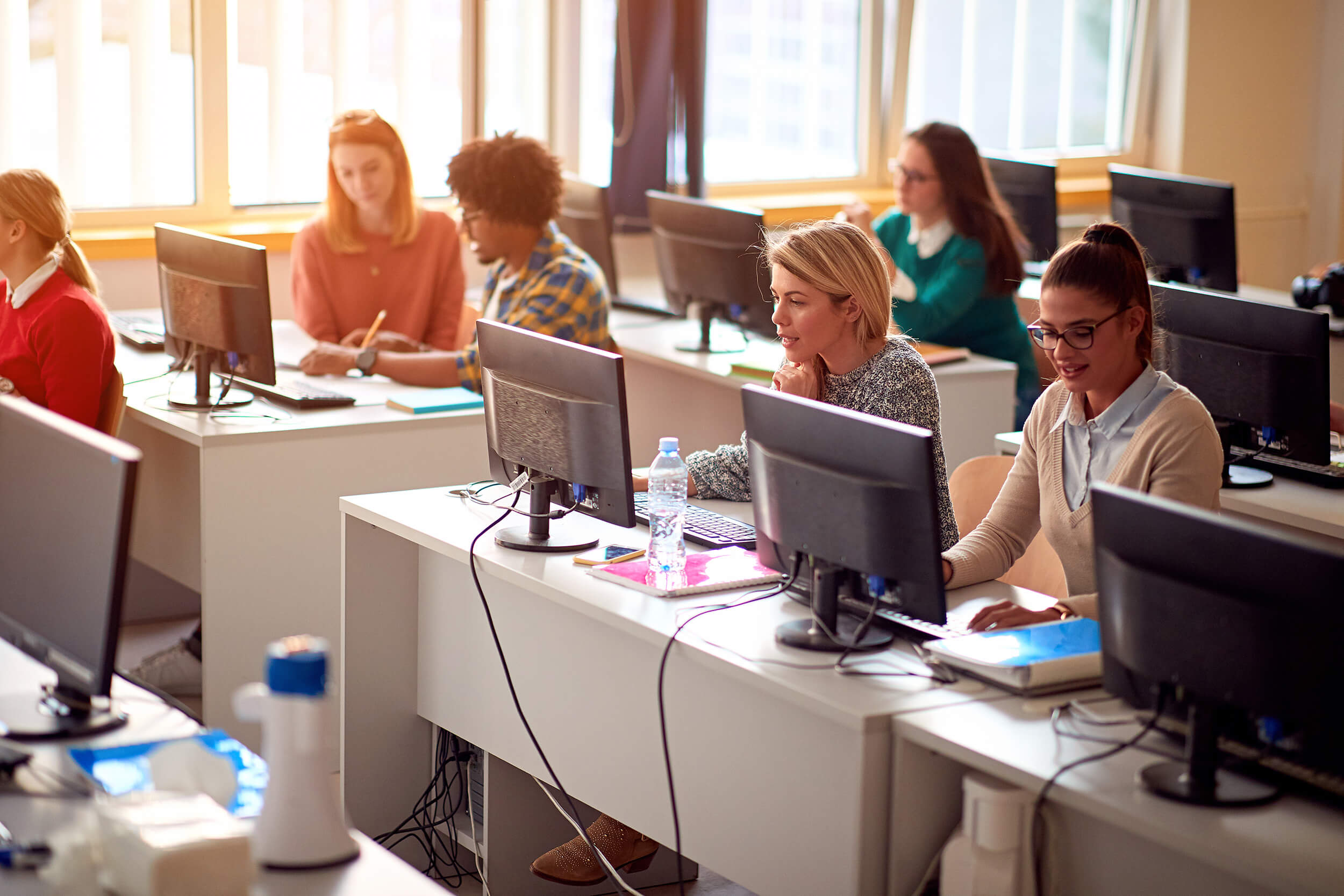 Mitarbeitende an ihren Arbeitsplatzrechnern im Büro